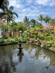 a fountain in a pond in a garden at Villa Padi Cangkringan in Sleman