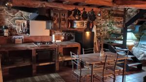 y cocina con mesa, sillas y fogones. en A Brava, en Sas de Penelas