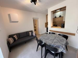 een woonkamer met een tafel en een bank bij Apartman Luna Sabunike in Privlaka