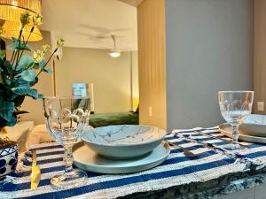 a table with a bowl and two glasses on it at Studio 84, Panoramic View in São Carlos