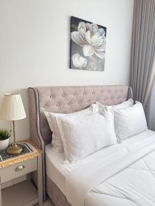 a bed with white pillows and a table with a lamp at Mamaqarl Homestay near KLIA with Wi-fi and Transport in Sepang