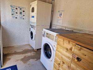 a washer and dryer sitting in a laundry room at Camping Paus'Art Déco in Villemer