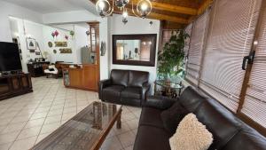 a living room with a leather couch and a table at Big Family Apartment in Sitia