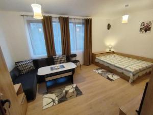 a living room with a bed and a couch at Студио за гости -Синхрон- Трявна in Tryavna