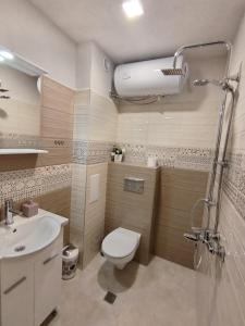 a bathroom with a toilet and a sink at Студио за гости -Синхрон- Трявна in Tryavna