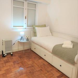 een slaapkamer met een bed, een raam en een tafel bij Caires Urban Nest in Braga +19 foto's