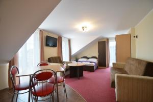 a hotel room with a couch and a table and chairs at Villa Savana in Mielno