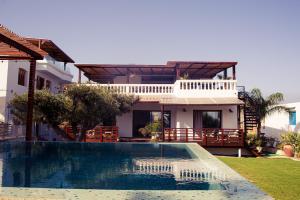 a villa with a swimming pool in front of a house at Dar Lina "Charme et nature" in El Haouaria