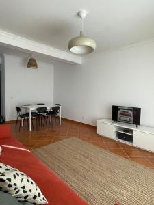a living room with a couch and a table with chairs at Casa Manel in Odemira