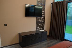 a living room with a flat screen tv on the wall at Richkas Chalet котедж з чаном-джакузі in Slavske