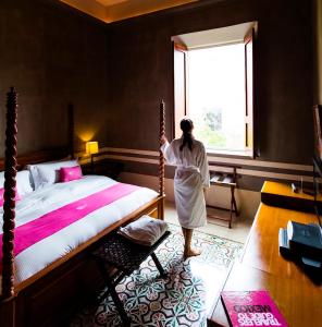 a person standing in a room with a bed at Rosas & Xocolate Boutique Hotel+Spa in Mérida