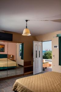 una camera con un letto e un grande specchio di Limanaki Apartments a Faliraki