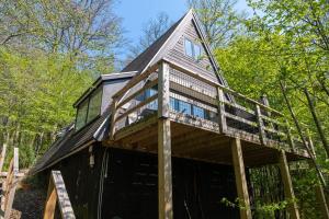 a house with a wrap around porch with a deck at Chalet Sumo in Durbuy