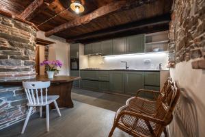 a kitchen with green cabinets and a table and chairs at Dorče Authentic Country House in Kojsko
