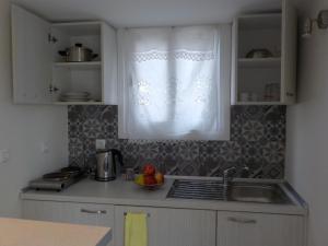 una cucina con lavandino e una finestra con tenda di Mini City Center Studio a Città di Rodi