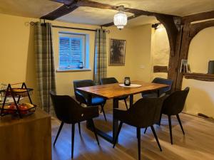a dining room with a wooden table and chairs at Gast- und Pensionshaus Pilgereck in Trendelburg