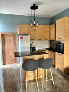 a kitchen with wooden cabinets and a black counter top at La Mansión in Lozenets