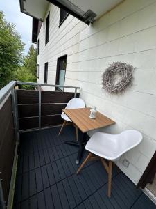 eine Terrasse mit einem Tisch und 2 Stühlen auf einem Balkon in der Unterkunft BergHerzl - Braunlage in Braunlage