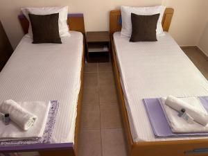 two beds with towels on them in a room at Thermos House Nydri in Nydri