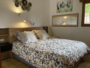 sypialnia z łóżkiem i lustrem w obiekcie Le jardin suspendu w mieście Collioure