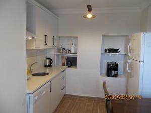 a white kitchen with a sink and a refrigerator at Stella Blu Apartments in Fethiye