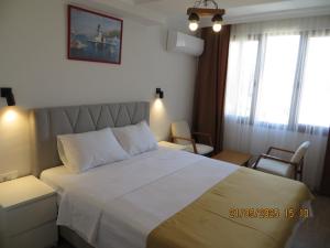 a bedroom with a large white bed and windows at Stella Blu Apartments in Fethiye