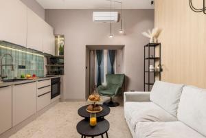 sala de estar con sofá blanco y silla verde en Apartments GReenRI, en Rijeka