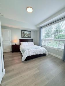 a bedroom with a bed and a large window at Peaks & Waters at Harrison Mills in Agassiz
