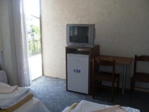 Habitación con TV y mesa pequeña con silla. en Residence Krstanoski, en Ohrid