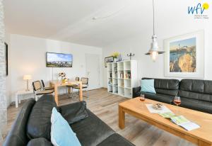 a living room with a couch and a table at Ferienhaus Caterlieschen Ferienwohnung 1 in Juist