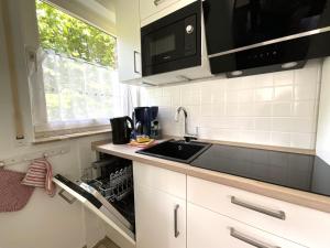 a kitchen with a sink and a microwave at Apartment Jadewind, Humenser 8a in Dangast