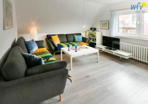 a living room with a couch and a table at Ferienhaus Caterlieschen Ferienwohnung 2 in Juist