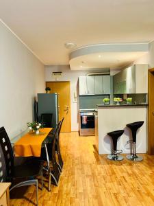 a kitchen and dining room with a table and chairs at VacationClub - Garden of Eden Apart Lilia L307 in Sveti Vlas