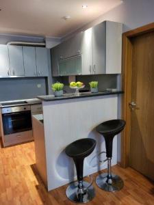 a kitchen with two stools at a counter in a kitchen at VacationClub - Garden of Eden Apart Lilia L307 in Sveti Vlas +2 photos