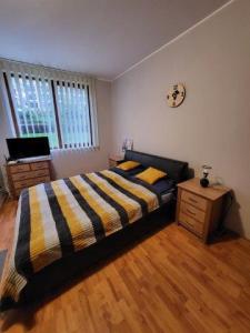 a bedroom with a bed and a dresser and a clock at VacationClub - Garden of Eden Apart Lilia L307 in Sveti Vlas