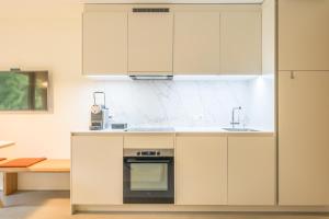 a kitchen with white cabinets and an oven at Edelweiss Ferienwohnung, Vista Flem in Flims +1 photo