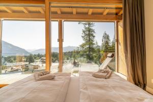 弗利姆斯Edelweiss Mountain Suites 07-08的一间有大窗户的房间里有两张床