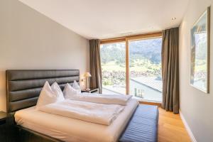 弗利姆斯Edelweiss Mountain Suites 07-08的一间卧室，里面有一张床和一扇大窗户。