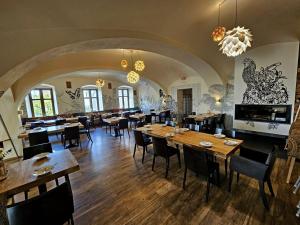 a restaurant with wooden tables and chairs in a room at Hotel U Feldů in Klimkovice