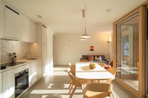 a kitchen and living room with a table and chairs at Edelweiss Stenna Cavorgia in Flims +3 photos