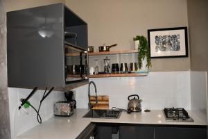 a kitchen with a stove and a counter top at Setlhoa one bed apartment in Gaborone +37 photos