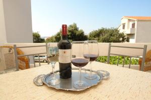 a bottle of wine and two glasses on a table at Apartments Dvorski in Mandre