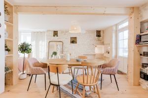 Una cocina y un comedor con mesa y sillas. en Charmante Maison Pierre à Ors, en Le Château-dʼOléron