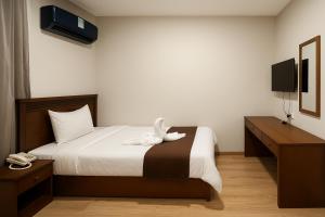 Postel nebo postele na pokoji v ubytování Miramar Evergreen Hotel