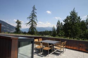 a patio with a table and chairs on a balcony at Edelweiss La Cerise in Flims