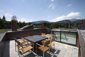 a patio with a table and chairs on a deck at Edelweiss La Cerise in Flims
