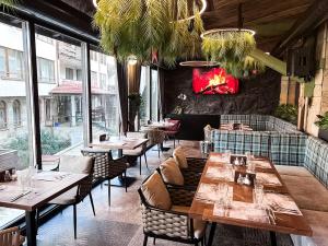 a restaurant with wooden tables and chairs and windows at SNOW PEAK TODORKA AND VIHREN APARTAMENT /NEXT TO THE LIFT/ 7 PERSONS/ in Bansko
