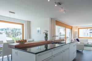 a kitchen with white cabinets and a large window at Edelweiss Casa Cassons in Flims