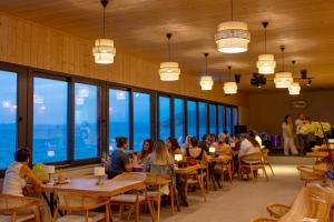 a group of people sitting at tables in a restaurant at Nest Beach Bungalows and Camping Datça in Datca