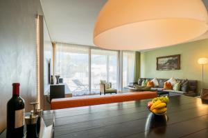 a living room with a couch and a table with a bowl of fruit at Edelweiss Mountain Suites 04-05 in Flims